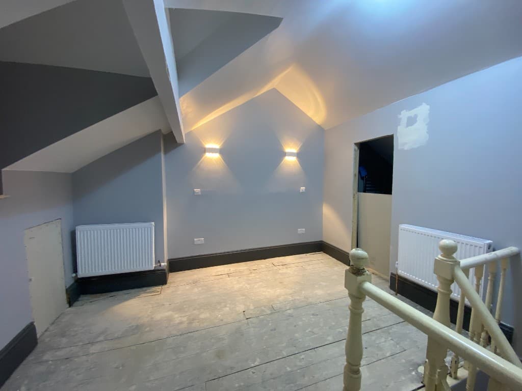 Loft room after painting, with grey walls, dark skirting and wall lights