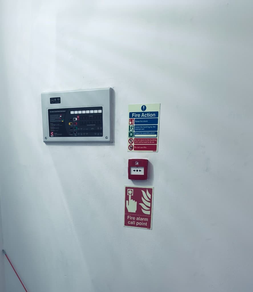 Completed fire-alarm control panel with Fire Action notice and call point
