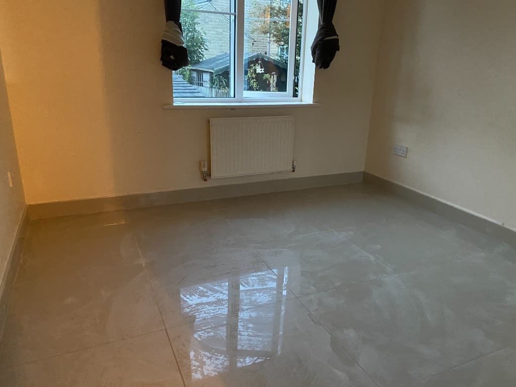 Glossy large-format floor tiles in an empty room