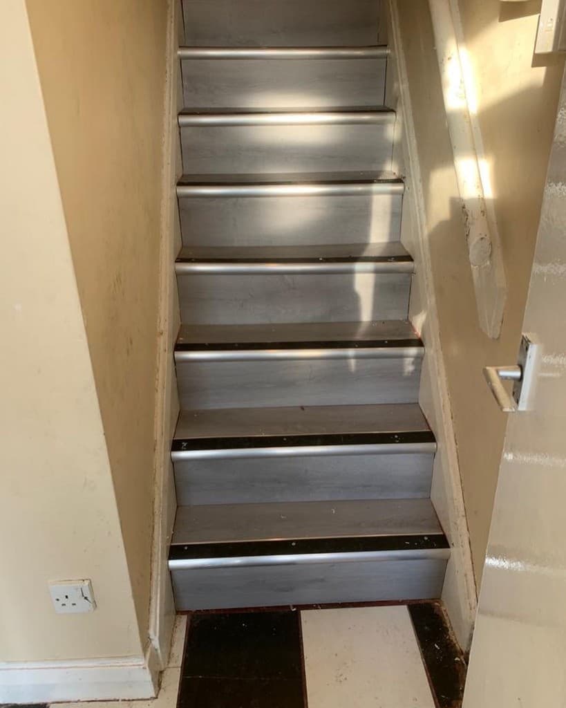 Staircase after installation of grey wood-effect treads and contrasting nosings