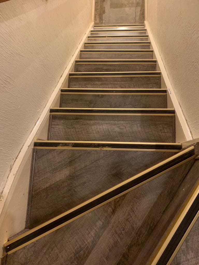 Staircase fitted with wood-effect flooring and contrasting nosings